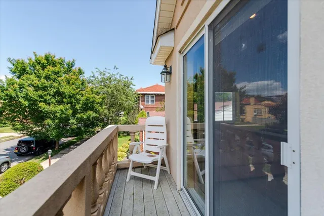 a balcony with wooden floor and outdoor seating