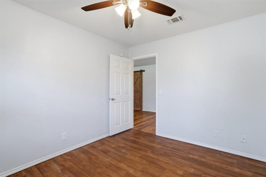 1974 County Road Powderly, TX 75473 - Photo 23 of 28 an empty room with wooden floor cabinet and ceiling fan