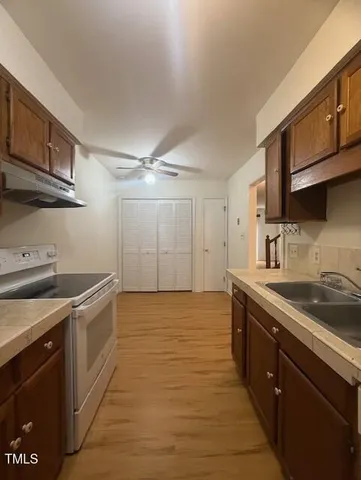 a kitchen with stainless steel appliances granite countertop a sink stove and cabinets