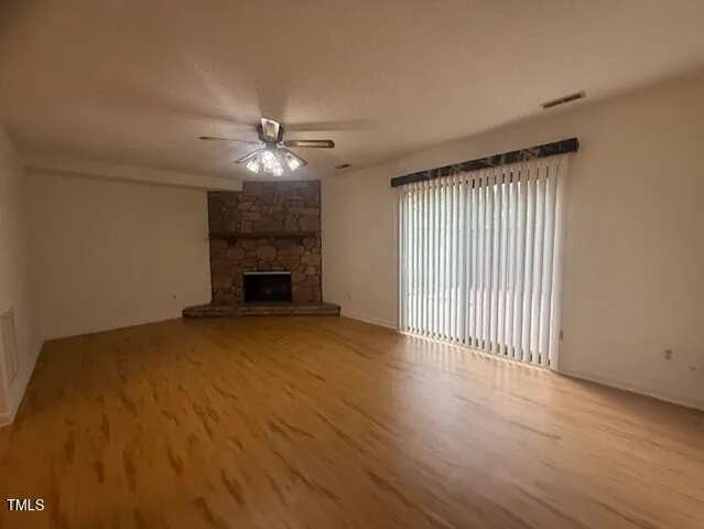 an empty room with windows and a fireplace