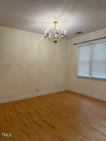 a view of a room with wooden floor and chandelier