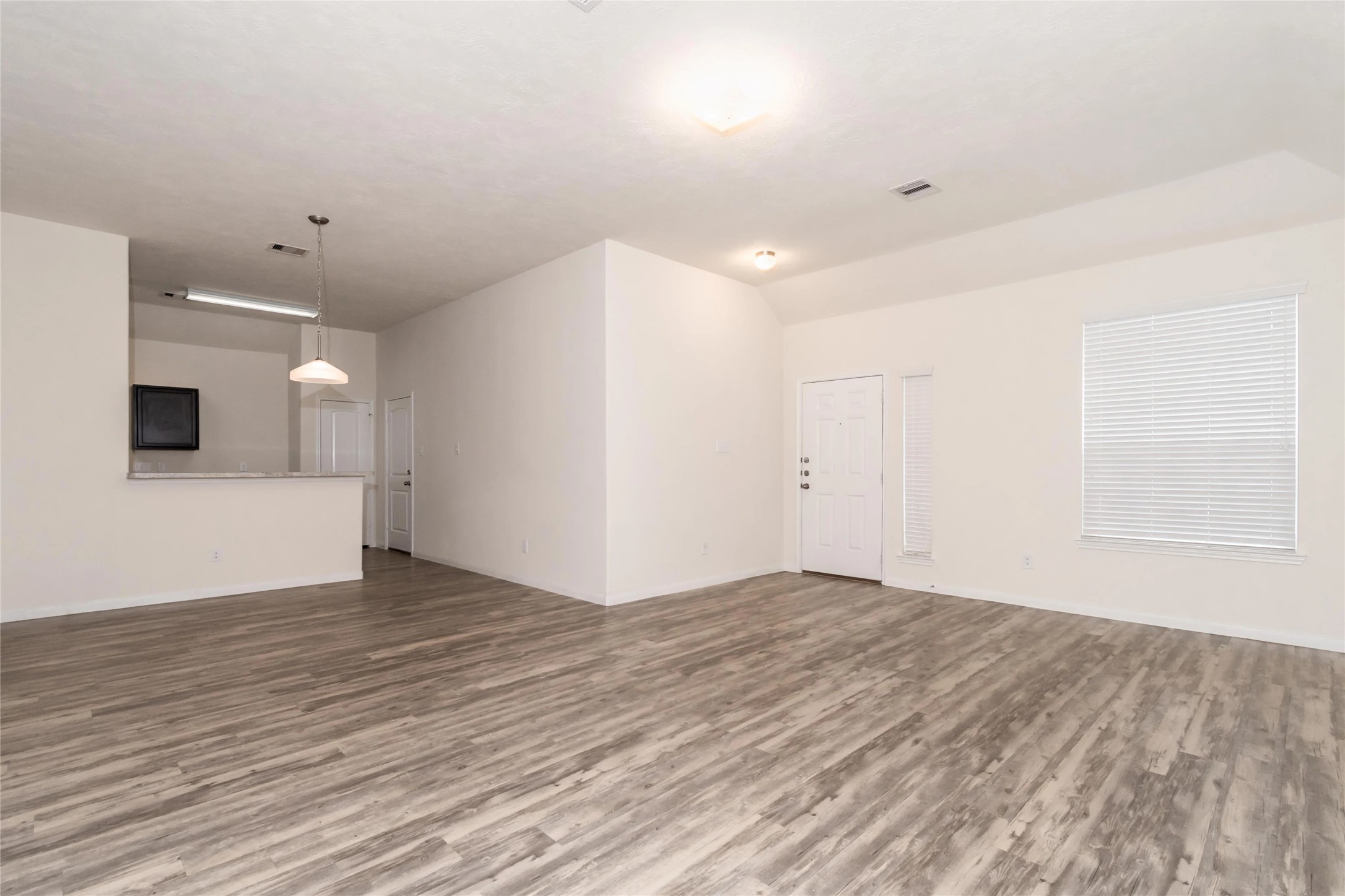 699 Fallow Lane Alvin, TX 77511 - Photo 3 of 7 an empty room with wooden floor and windows