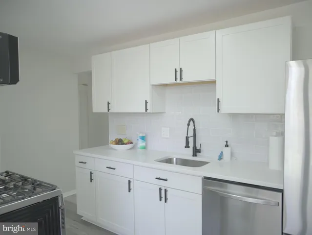 a kitchen with white cabinets and a sink