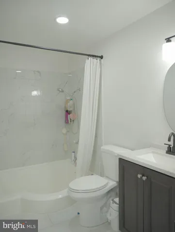 a bathroom with a granite countertop sink a toilet and a mirror