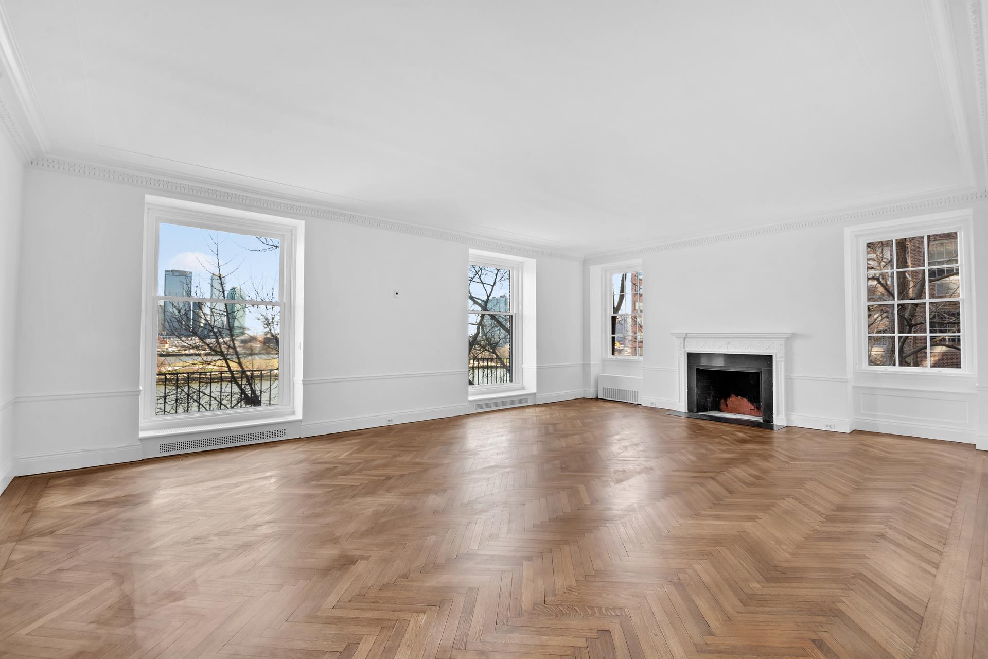 1 Sutton Place South, Unit 4C Manhattan, NY 10022 - Photo 2 of 35 a view of an empty room with window and fireplace