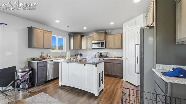 a kitchen with a sink cabinets stainless steel appliances and a window