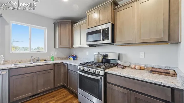 a kitchen with stainless steel appliances granite countertop a sink stove and microwave