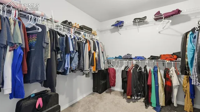 a view of walk in closet with clothes