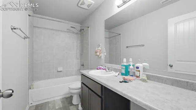 a bathroom with a granite countertop sink toilet and shower