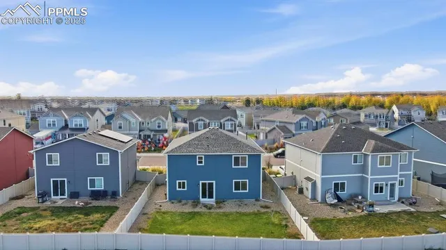 a view of a big house with a big yard and large trees
