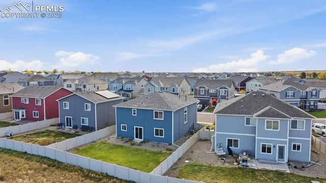 an aerial view of a house with swimming pool and a yard