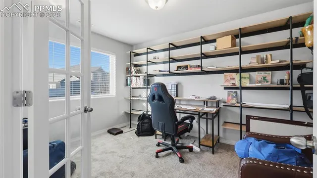 a view of a workspace with furniture and a window