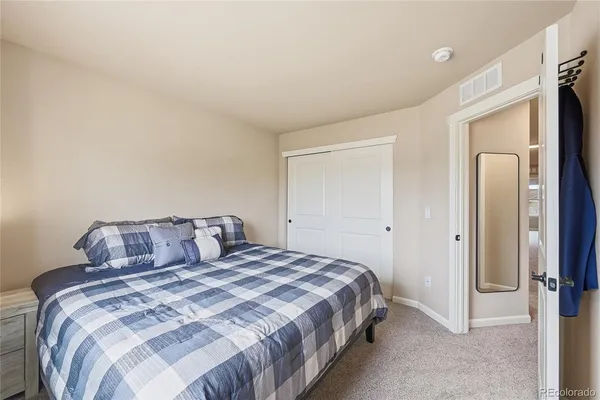 a bedroom with a large bed and a flat tv screen on dresser