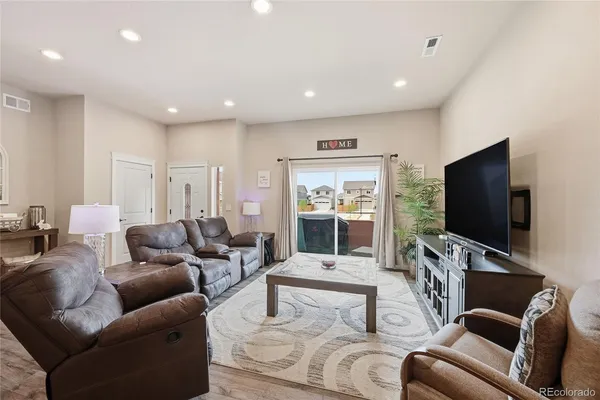 a living room with furniture kitchen view and a chandelier