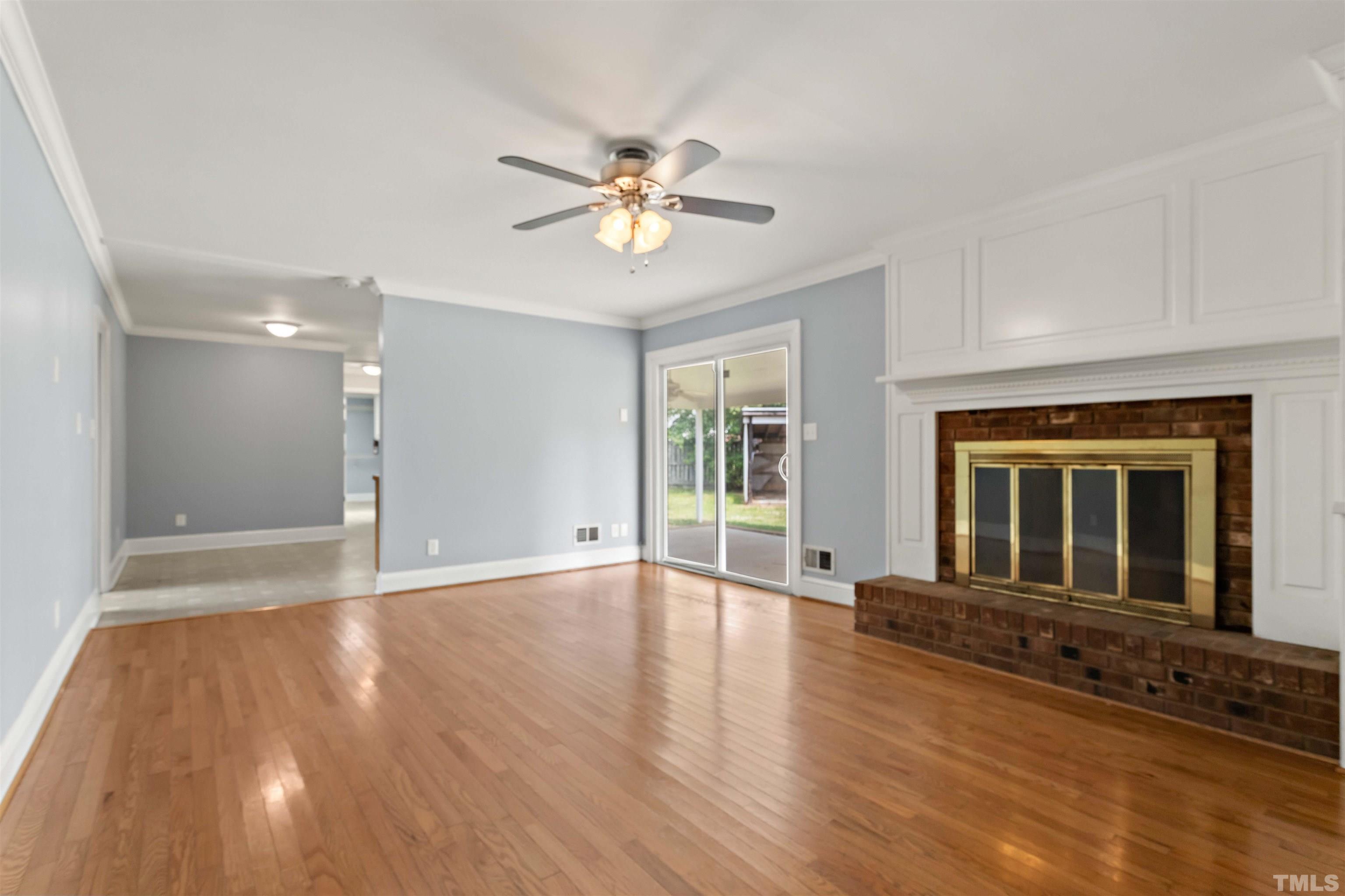 4811 Greenbrier Road Raleigh, NC 27603 - Photo 31 of 41 a view of an empty room with chandelier fan and wooden floor