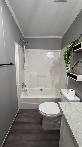 a bathroom with a granite countertop bathtub shower sink vanity and toilet
