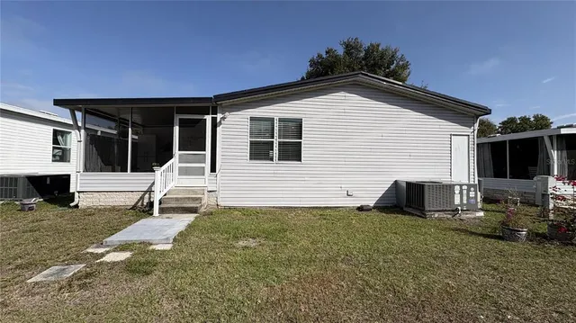 a view of a house with backyard and sitting area