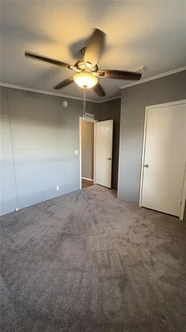a view of an empty room and chandelier fan