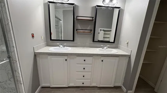 a bathroom with double vanity sink and mirror