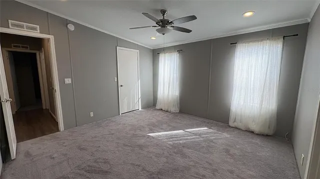 an empty room with windows and cabinet