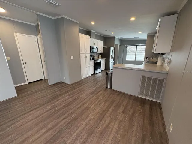 a view of a kitchen with wooden floor and a window