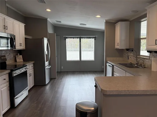 a kitchen with stainless steel appliances granite countertop a sink stove and refrigerator
