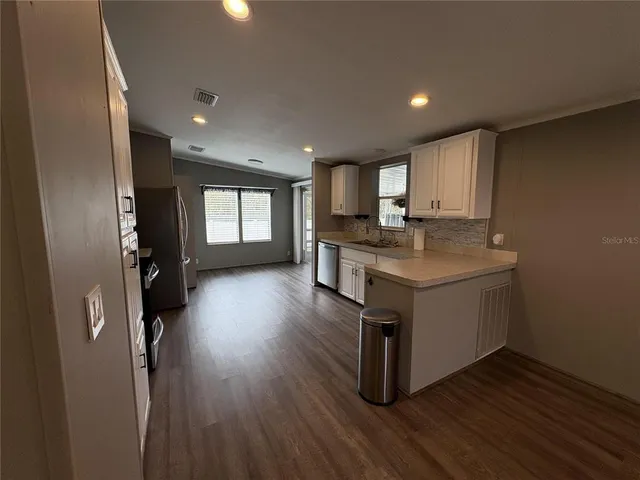 a kitchen with a refrigerator and a stove top oven