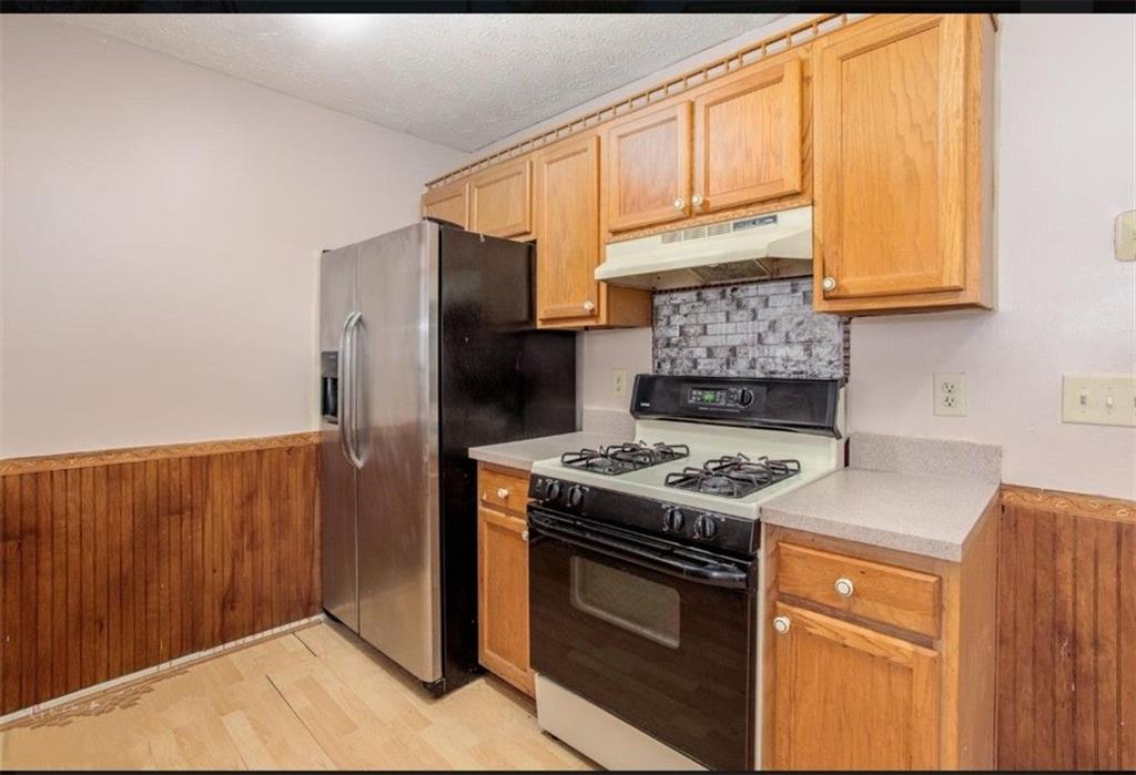 602 Pine Tree Trail Atlanta, GA 30349 - Photo 4 of 7 a kitchen with stainless steel appliances granite countertop a stove a refrigerator and a sink