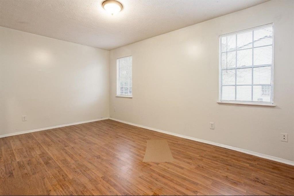 602 Pine Tree Trail Atlanta, GA 30349 - Photo 6 of 7 an empty room with wooden floor and windows