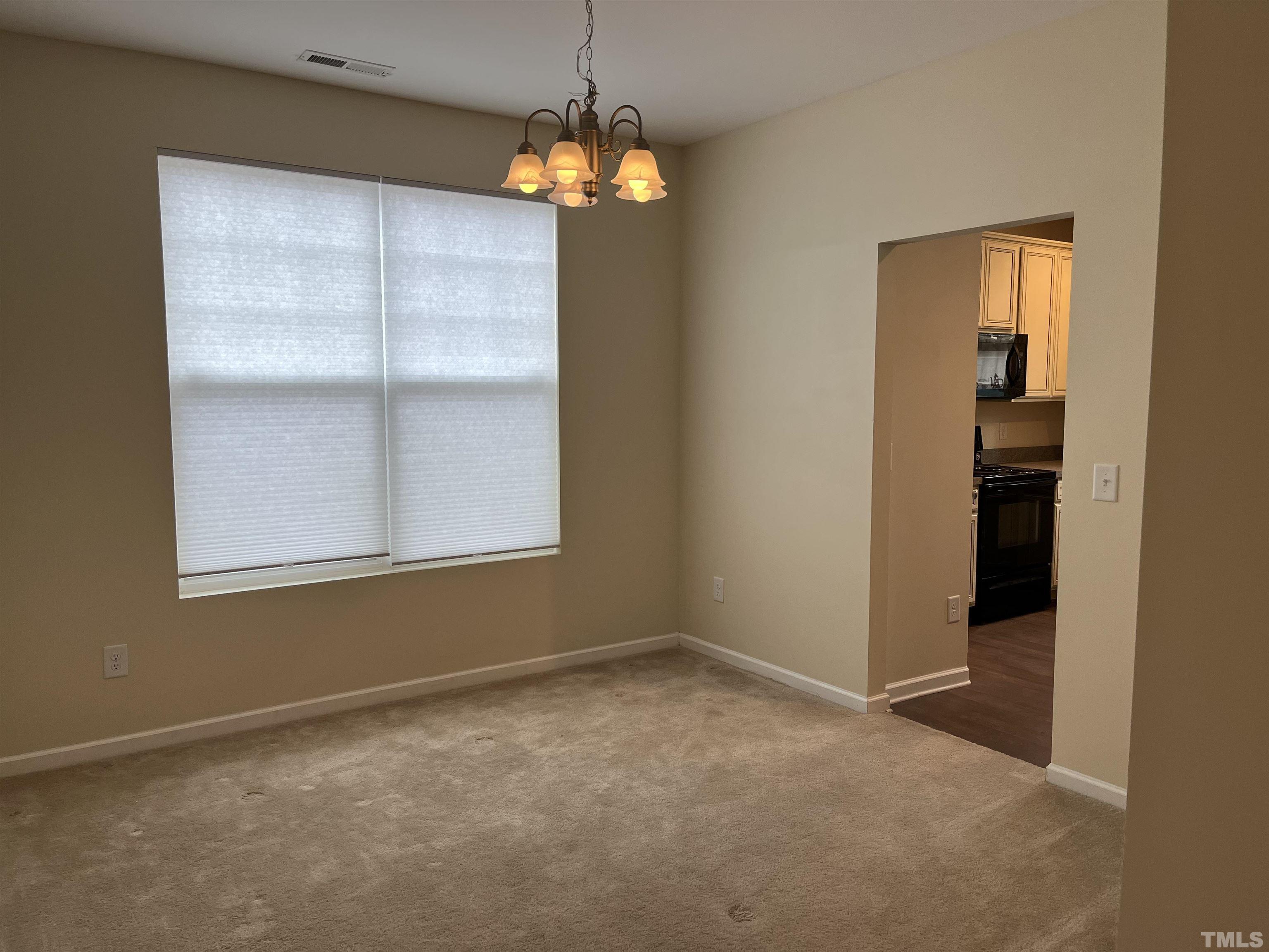 2499 Longshadow Drive Graham, NC 27253 - Photo 3 of 14 an empty room with windows and chandelier fan