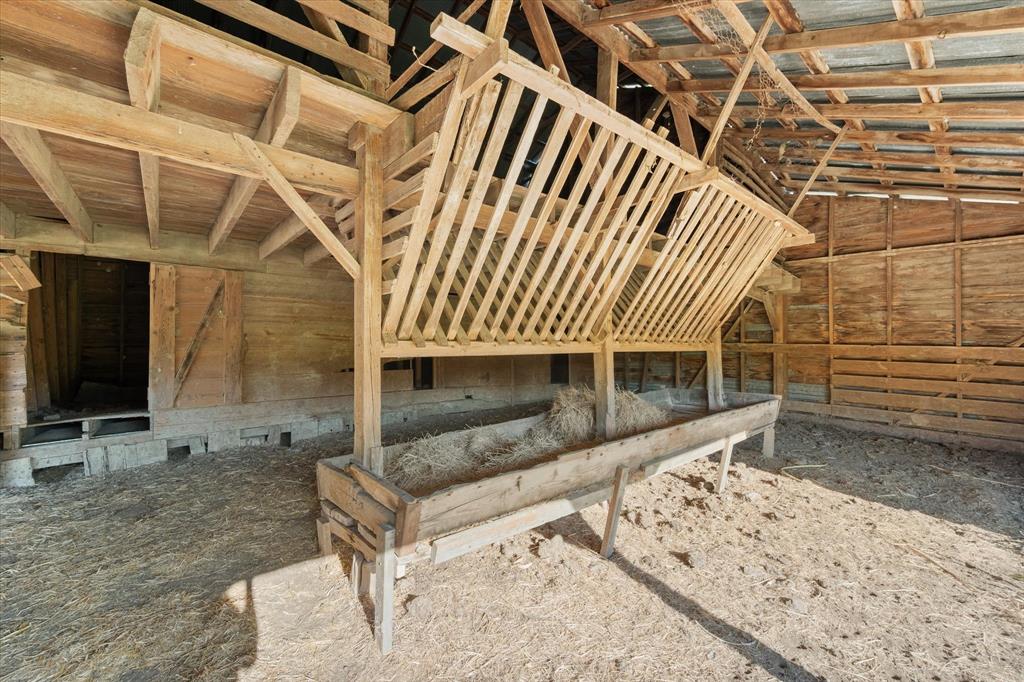 917 Goodwyn Road Italy, TX 76651 - Photo 30 of 40 Wooden interior structure featuring exposed timber framing and a slatted hay feeder