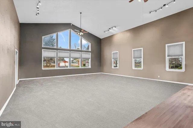 a living room with furniture a flat screen tv and a window