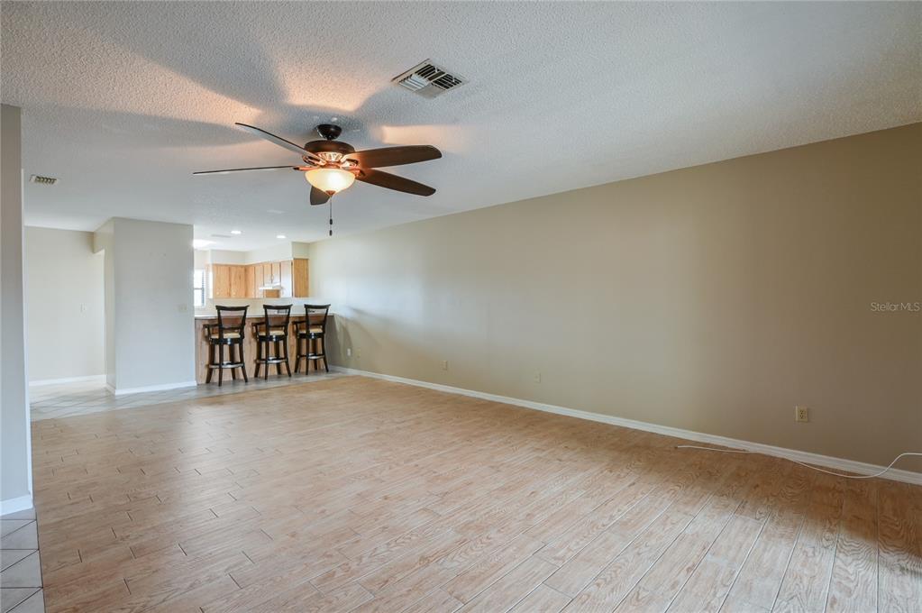 11001 Southeast Sunset Harbor Road, Unit H52 Summerfield, FL 34491 - Photo 17 of 31 a view of wooden floor and a chandelier fan in an empty room