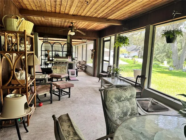 an aerial view of a house with a yard and trees all around