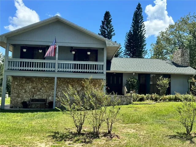 a kitchen with stainless steel appliances a stove a refrigerator a sink a dining table and chairs with wooden floor