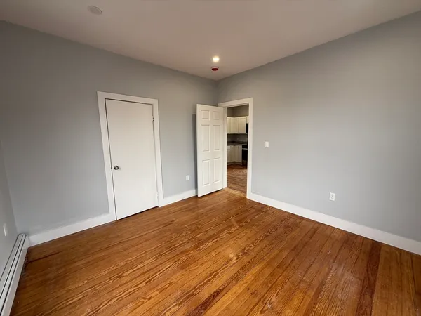 a view of empty room with wooden floor