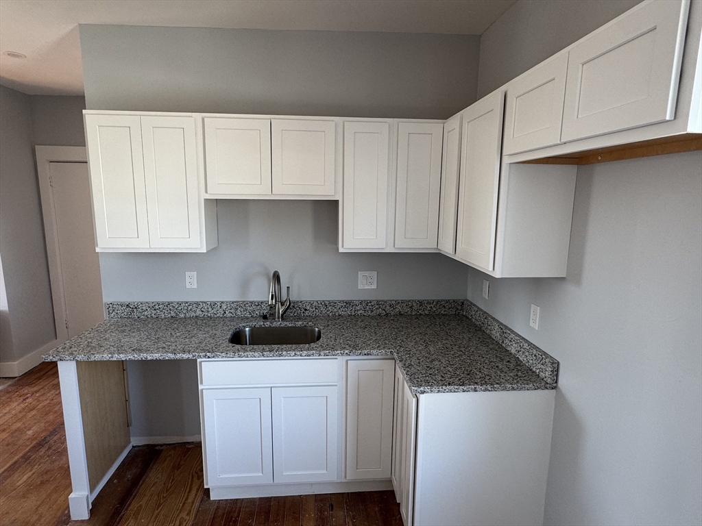 8 Carnes Street, Unit 2R Lynn, MA 01905 - Photo 3 of 15 a kitchen with granite countertop white cabinets and a stove