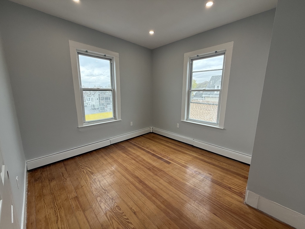 8 Carnes Street, Unit 2R Lynn, MA 01905 - Photo 8 of 15 an empty room with wooden floor and windows