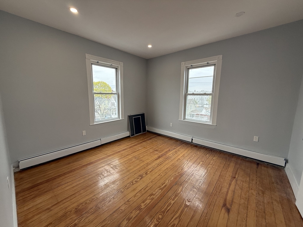 8 Carnes Street, Unit 2R Lynn, MA 01905 - Photo 10 of 15 a view of an empty room with wooden floor and window