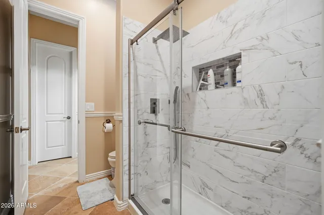 a bathroom with a granite countertop double vanity sink and a mirror