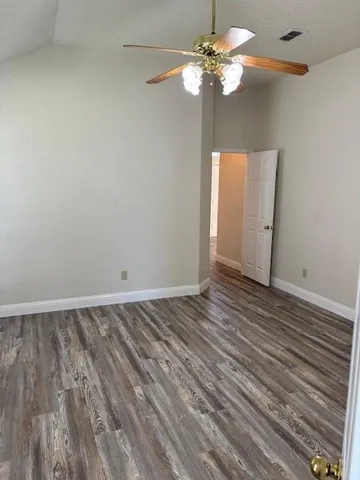 a view of a room with wooden floor and a ceiling fan