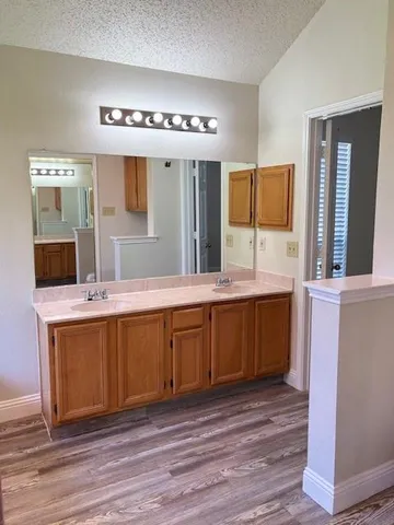 a spacious bathroom with a granite countertop sink and a large mirror