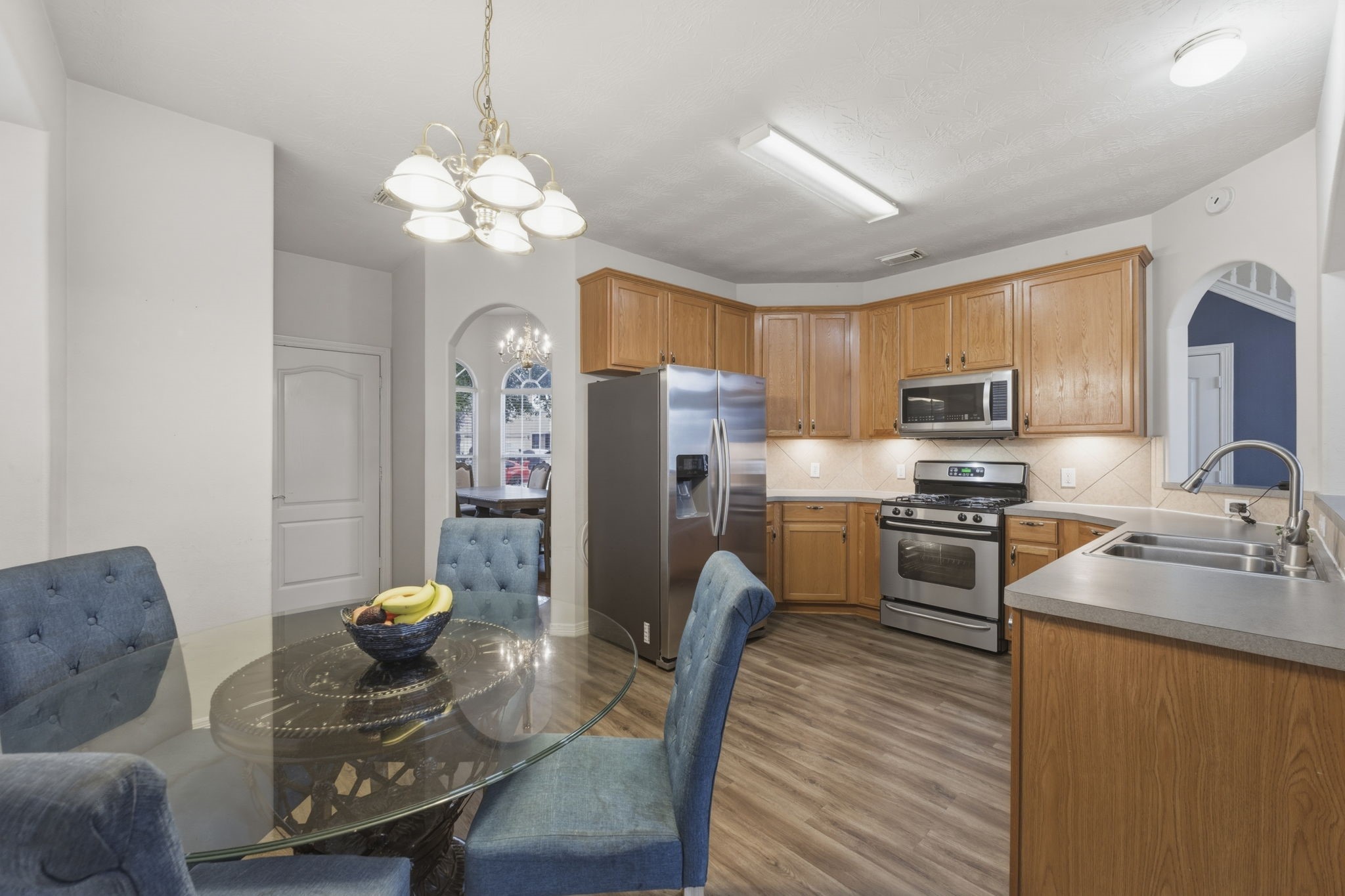 3006 Country Boy Court Spring, TX 77373 - Photo 5 of 17 a kitchen with stainless steel appliances granite countertop a refrigerator a sink dishwasher a stove a dining table and chairs with wooden floor