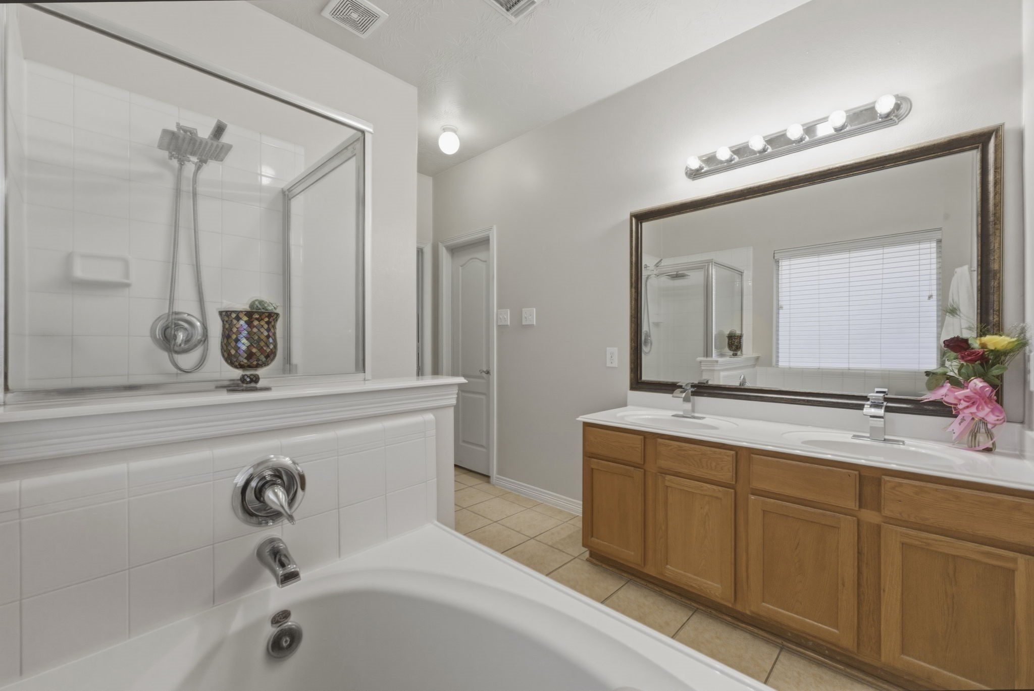 3006 Country Boy Court Spring, TX 77373 - Photo 9 of 17 a bathroom with a double vanity sink a mirror and a bathtub