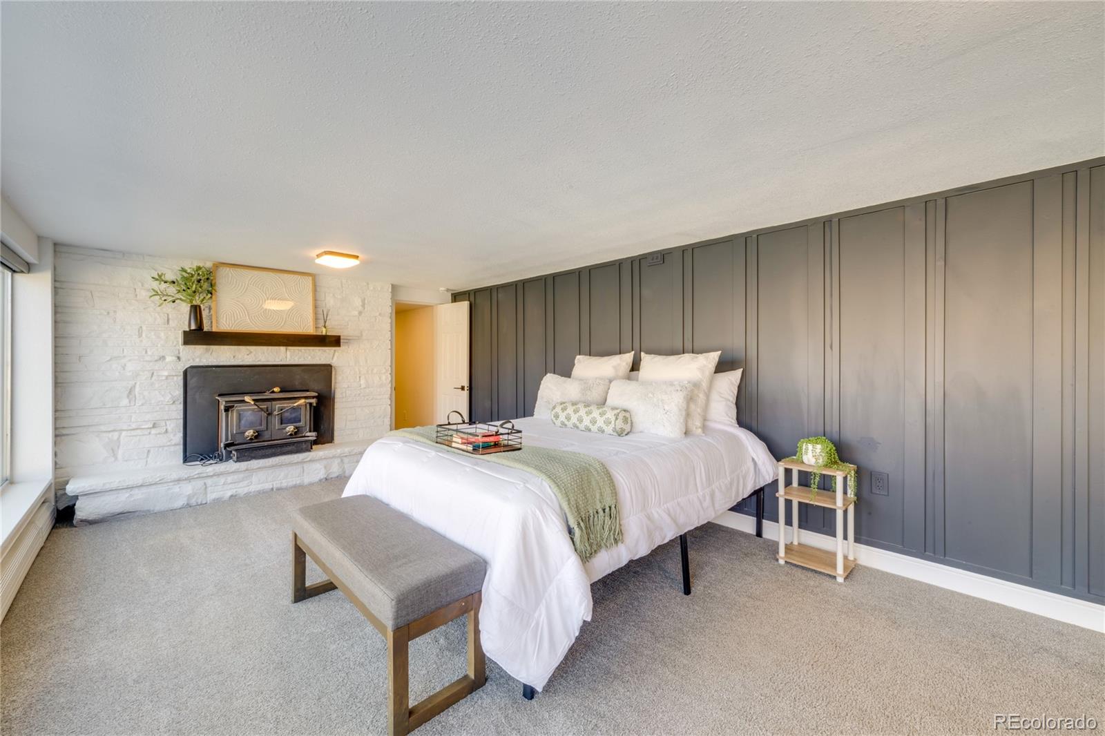 6811 West 48th Avenue Wheat Ridge, CO 80033 - Photo 13 of 33 a spacious bedroom with a bed and a fireplace