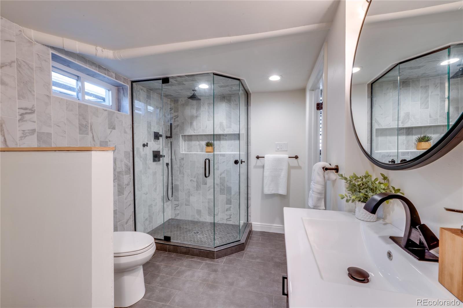 6811 West 48th Avenue Wheat Ridge, CO 80033 - Photo 19 of 33 a bathroom with a sink a toilet and a mirror