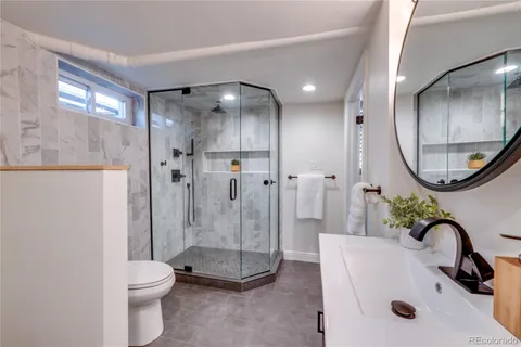 a bathroom with a sink a toilet and a mirror