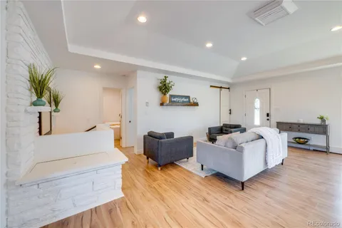 a living room with furniture fireplace and wooden floor