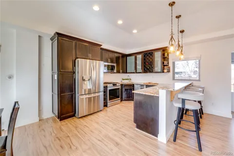 a kitchen with a refrigerator a stove top oven a sink dishwasher and wooden floor