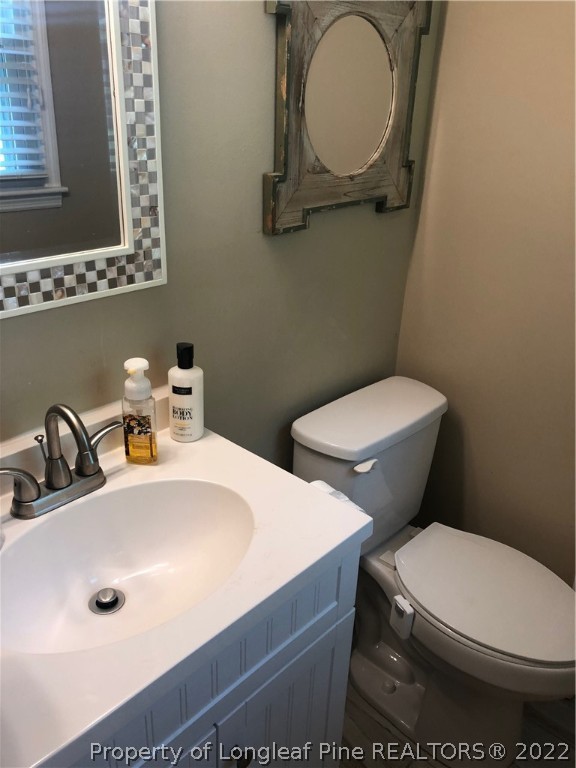 310 Old Farm Road Raeford, NC 28376 - Photo 16 of 29 a bathroom with a toilet a sink and mirror